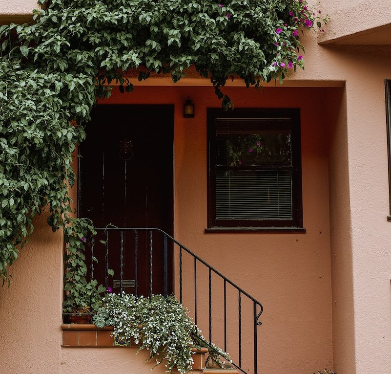 a house with a balcony and plants on the side