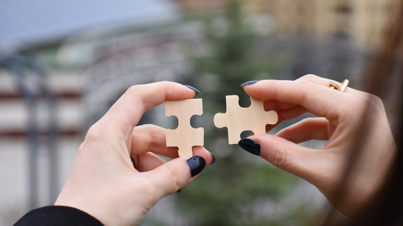 a few hands holding a small white object